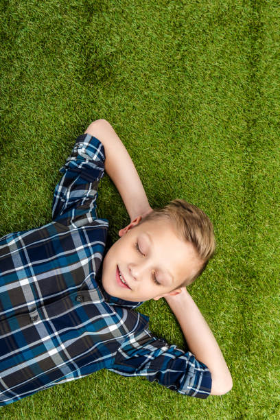 istock top view of cute boy lying on lawn with closed eyes 1089417876