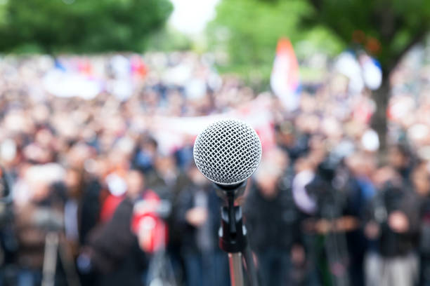 istock Microphone in focus against blurred protest or public demonstration 1089422280