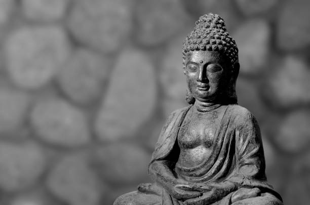 istock Buddha statue sitting in meditation pose against blurred golden background. 1089425942