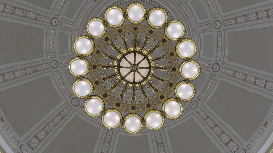 Little Rock, Arkansas, United States - June, 2015: Chandelier in the upper portion of the inside of the rotunda at the Arkansas State Capitol building. The photo was taken looking up from a lower level floor of the building.