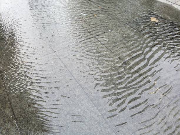istock Ripples of water in large puddle downtown 1089432164