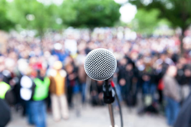 istock Microphone in focus against blurred protest or public demonstration 1089434568
