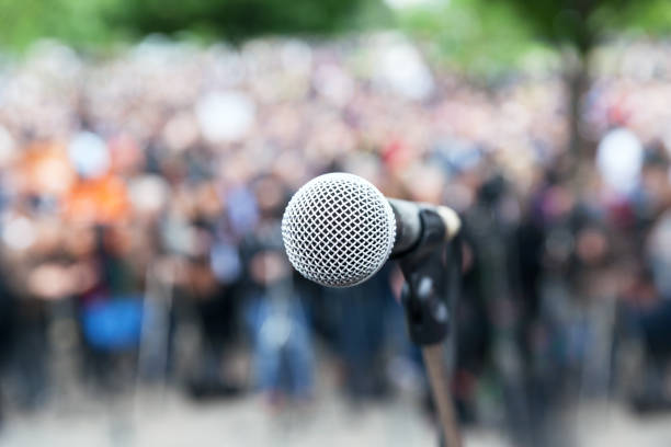 istock Microphone in focus against blurred protest or public demonstration 1089444788