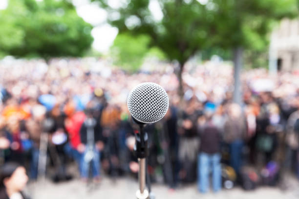 istock Microphone in focus against blurred protest or public demonstration 1089450982