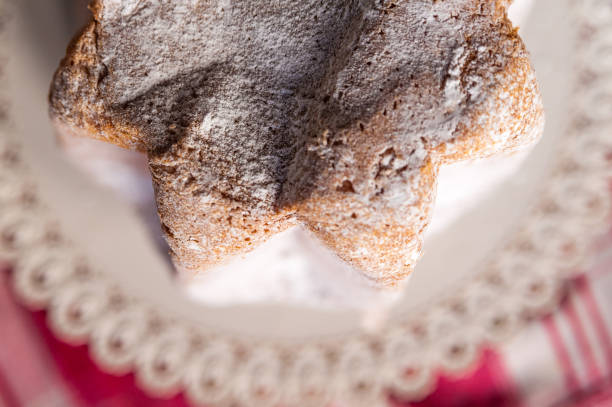 close up from above of slices of traditional italian christmas cake called pandoro of verona with sugar on top on table with red cloth stock photo