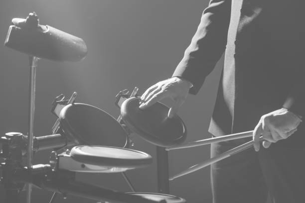 istock Drummer. The guy holds drum sticks in his hand against the background electronic drum. Young man with drum sticks. 1089454960