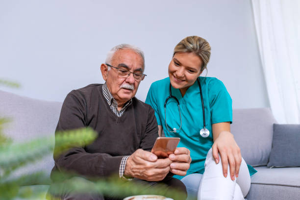 istock Smiling senior man and caregiver with a tablet or smartphone 1089458556