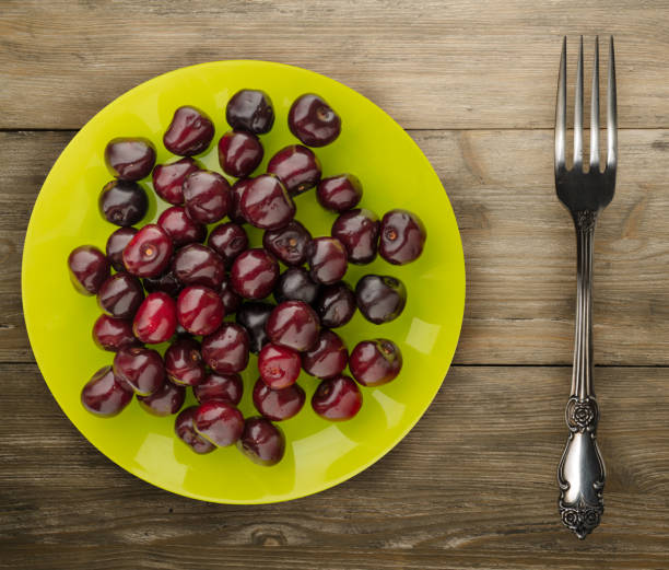 berry cherry on a plate on a wooden background. fruit diet. vegan food