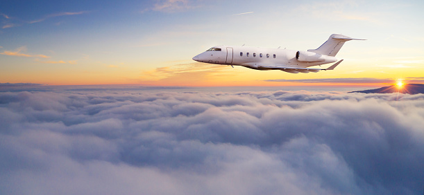 Luxury private jetliner flying above clouds. Modern and fastest mode of transportation, symbol of luxury and business traveling.