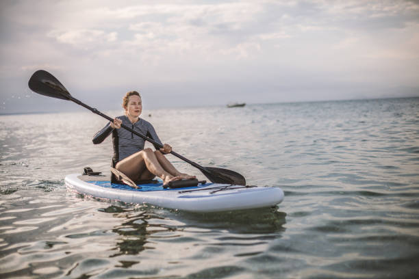 istock Woman in wetsuit with a paddle board 1089475770