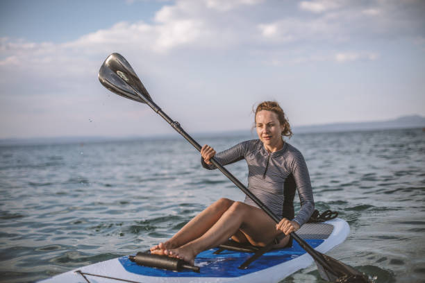 istock Woman in wetsuit with a paddle board 1089477060