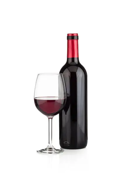 Photo of Red wine bottle and wineglass shot on white background