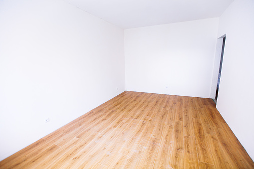 Photo of a white empty scandinavian room interior with wooden floor and walls. Home nordic interior.