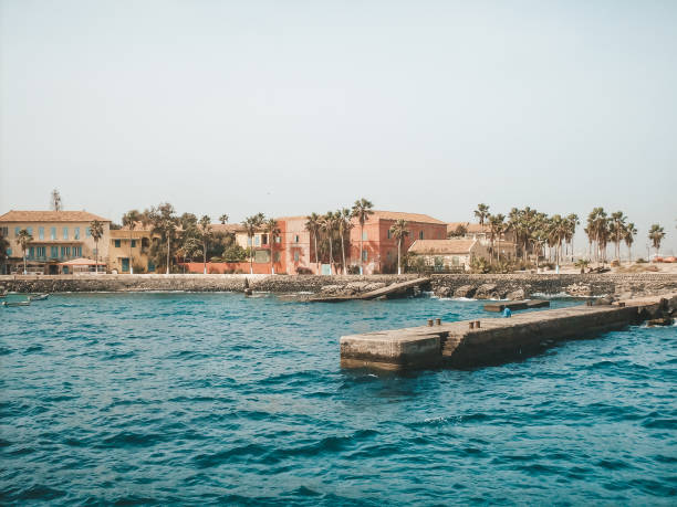 Senegal beach with concrete pier and architecture, view from water.