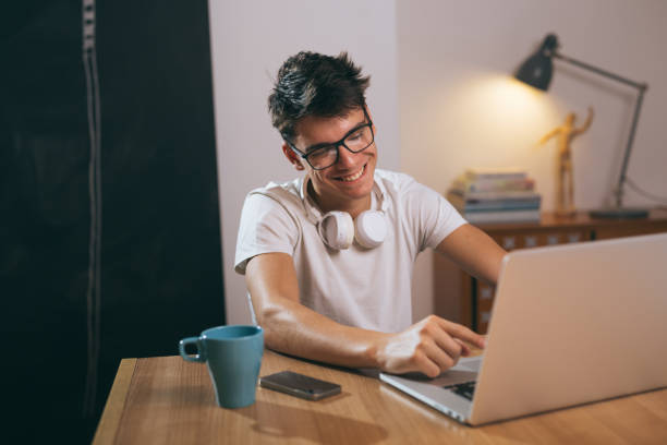 istock teenage boy using laptop at his home 1089486862