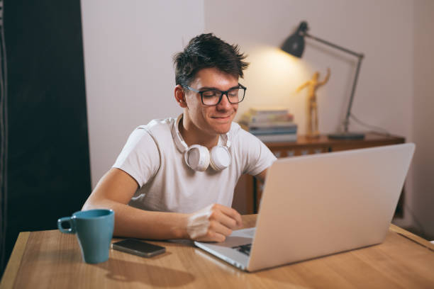 istock teenage boy using laptop at his home 1089486864