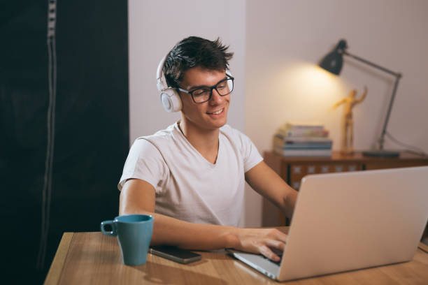 istock teenage boy using laptop at his home 1089487012