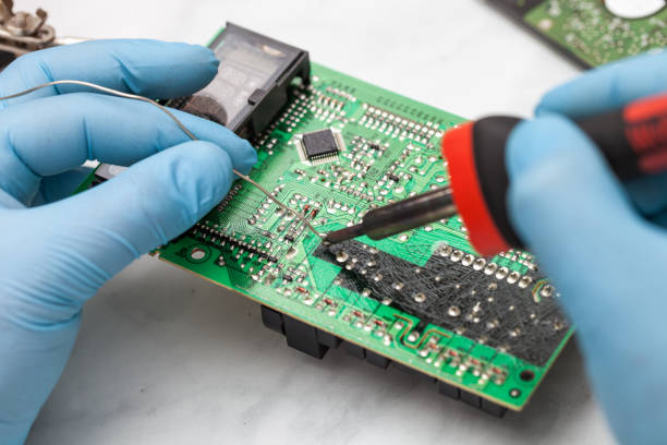 istock Hands wearing gloves solders and verifies computer circuit board using soldering iron and multimeter 1089487034