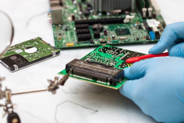 istock Hands wearing gloves solders and verifies computer circuit board using soldering iron and multimeter 1089487040