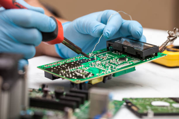 istock Hands wearing gloves solders and verifies computer circuit board using soldering iron and multimeter 1089487772