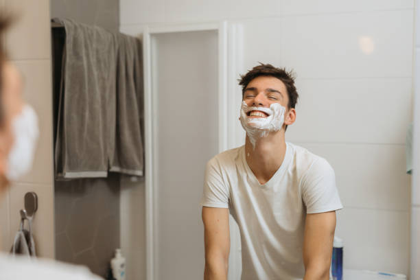 man shaving inbathroom - shaving men shaving cream mirror imagens e fotografias de stock