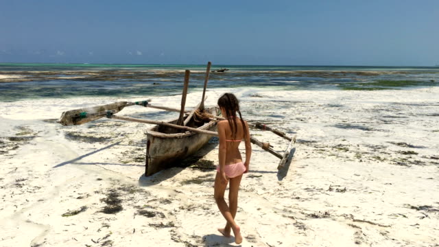 Young Girl Finding a Wooden Catamaran on Sandy Beach on Tropical Island