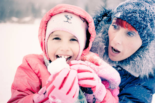 istock Worried Mother When Daughter Eats Snow 1089493768