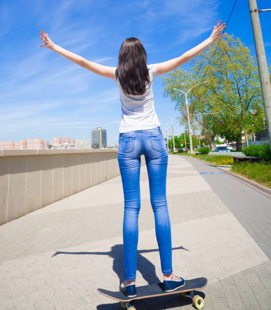 istock Woman skateboard, full height, back, riding 1089501668