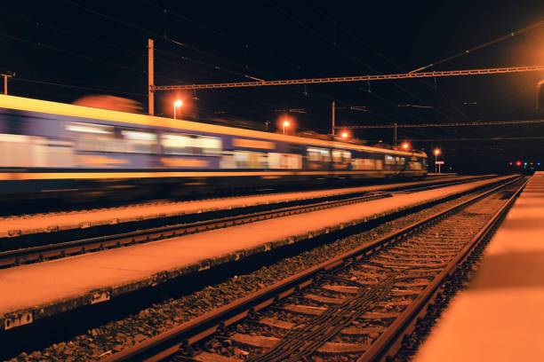 istock Passenger train on railroad tracks at night  Blurred motion 1089512198