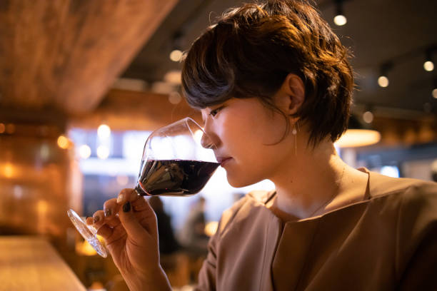 jovem mulher vermelha beber vinho no bar - wine red wine glass bar counter - fotografias e filmes do acervo