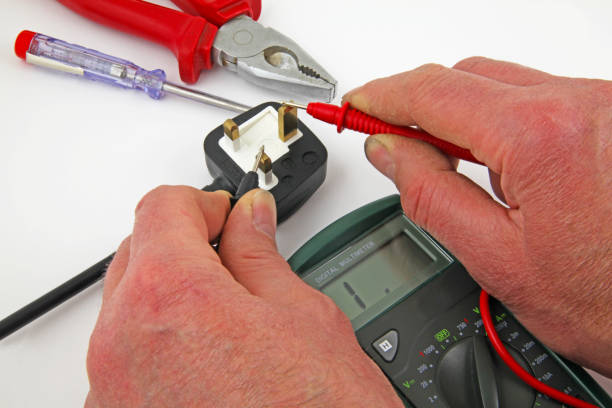 Earth insulation testing An electrician testing for a earth fault  between the live cable and earth with a multi meter three pin plug stock pictures, royalty-free photos & images