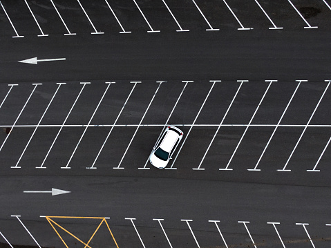 A directly above view of a lonely car in a parking lot