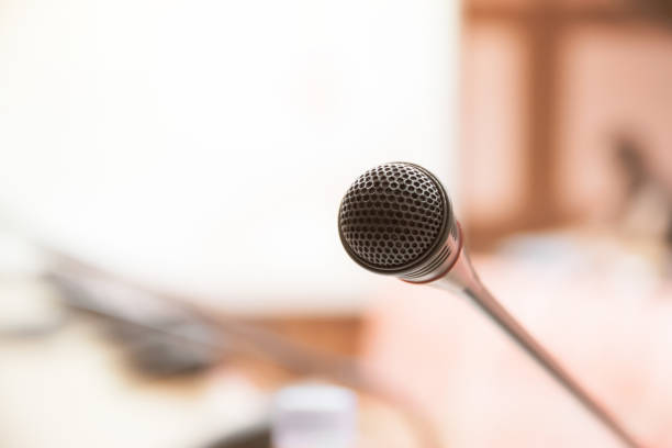 istock Mini Microphone on abstract blurred conference hall for speaker on stage in seminar room background, Business meeting and education in teaching classroom concept 1089523278