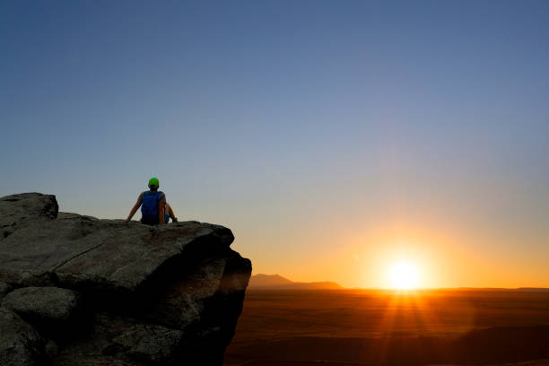 istock Woman Hiker Rests On Rock Promontory While Watching Sunset 1089530114