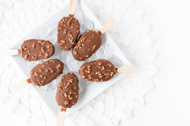 istock caramel and chocolate nut covered ice cream sticks on ice 1089539898