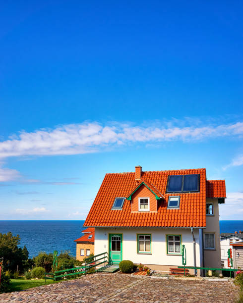 maison individuelle moderne avec des tuiles rouges et panneaux solaires. salon avec vue sur la mer baltique sur l’île de rügen. - detached house home interior building exterior outdoors photos et images de collection