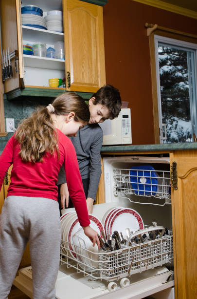 istock Boy and girl emptying dishwasher machine 1089561810