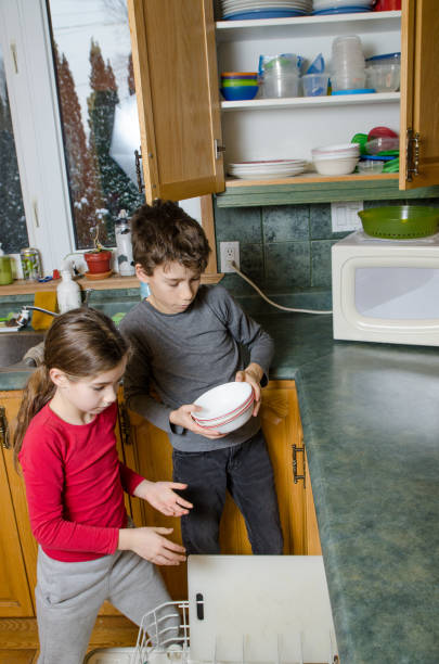 istock Boy and girl emptying dishwasher machine 1089561952