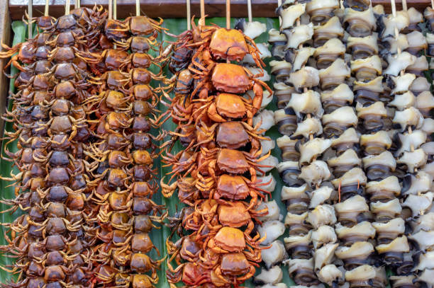 istock Small crab grilled and shells skewer with bamboo on a banana leaf, Arranged in a row. 1089563400