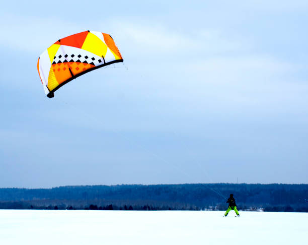 istock Snowkiting. A man in winter is engaged in snowkiting on skis. 1089592490