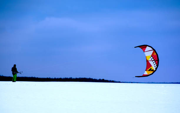 istock Snowkiting. A man in winter is engaged in snowkiting on skis. 1089592966