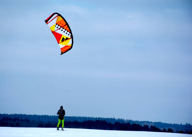 istock Snowkiting. A man in winter is engaged in snowkiting on skis. 1089593014