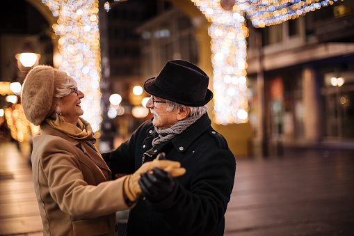 Grandma and grandpa enjoying winter holidays on the street dancing