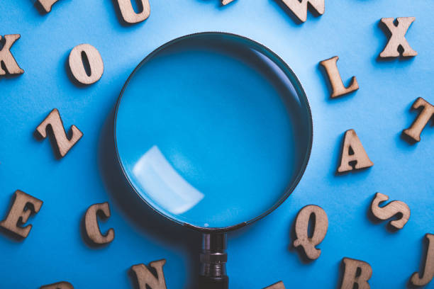 istock Magnifying With Wooden Alphabets Around On Blue Background 1089615310