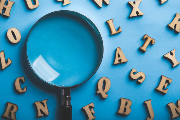 istock Magnifying With Wooden Alphabets Around On Blue Background 1089615316
