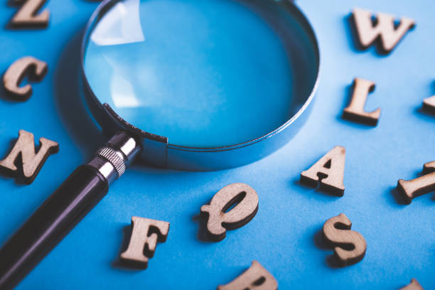 istock Magnifying With Wooden Alphabets Around On Blue Background 1089615322