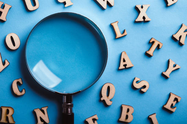istock Magnifying With Wooden Alphabets Around On Blue Background 1089615336