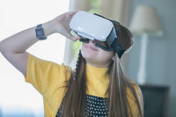 istock Preteen girl using virtual reality goggles while doing homework in living room 1089617328
