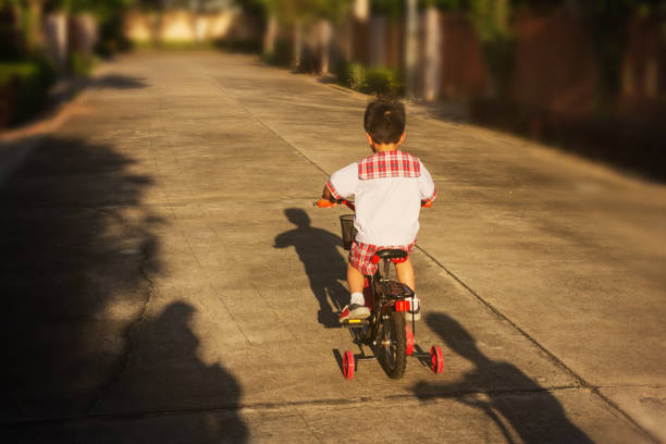 Happy boy with his bike.Kid learns to ride a bicycle on the road.