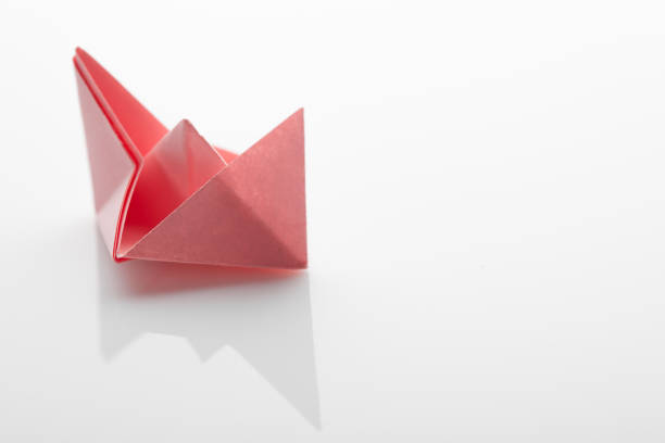 istock Red origami paper ship on white background 1089629778